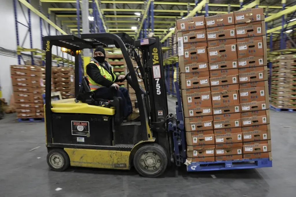 Forklift moving a pallet of cartons in a warehouse