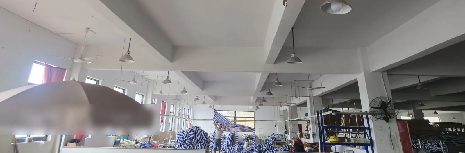 Sewing workshop where workers stitch striped canopy panels